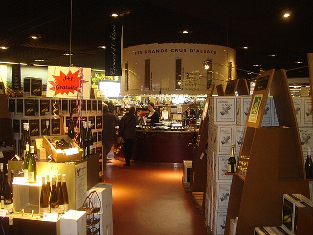 Cave à vin de la cave Wolfberger à Eguisheim avec plusieurs bouteilles. Lieu en intérieur pour éviter la pluie
