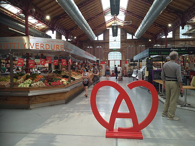 ntérieur du marché couvert de Colmar avec le logo Alsace, un espace idéal pour se restaurer à l'abri de la pluie dans le Haut-Rhin.